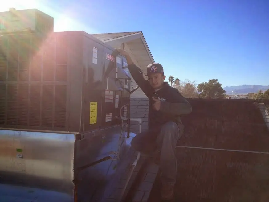 HVAC technician performing Boiler Repair on a rooftop unit in Merrill
